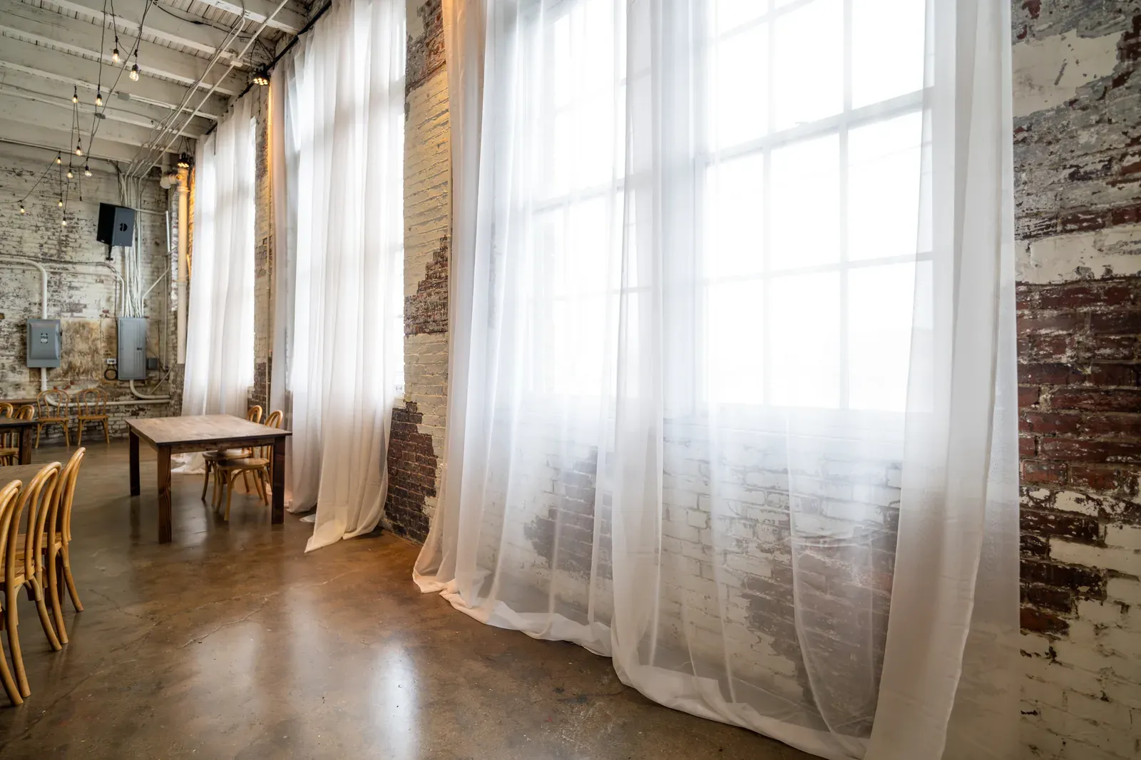 Exposed brick walls and Edison bulb string lights in a historic downtown Indianapolis event space