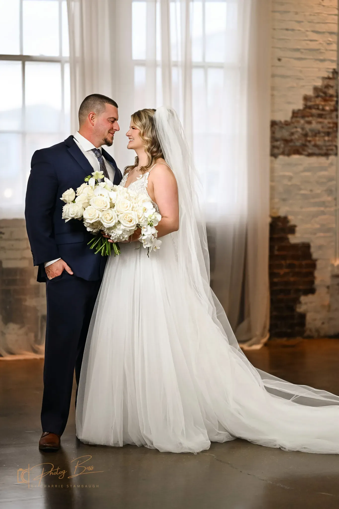 A wedding ceremony aisle set up at 24 Shelby with chairs in rows along the original 1898 brick walls under Edison string lights, the kind of room flow couples need to test on a venue tour