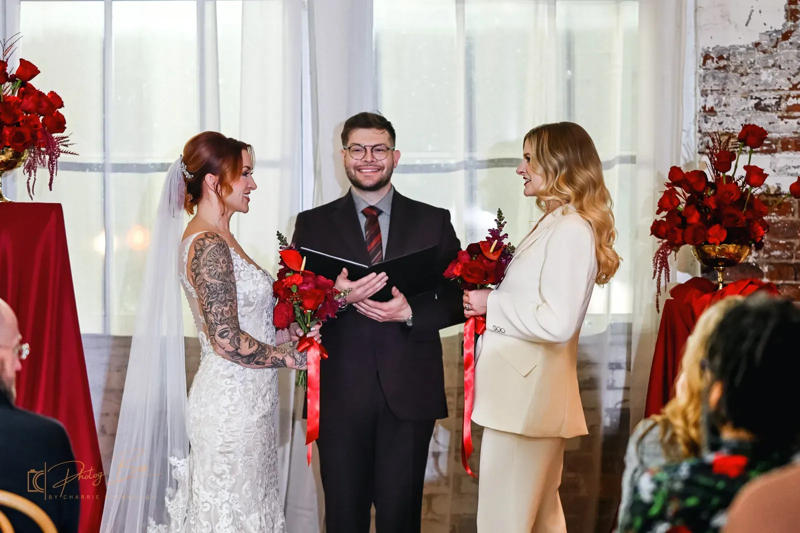 Couple exchanging vows at 24 Shelby with officiant, exposed brick walls, and natural light through original windows