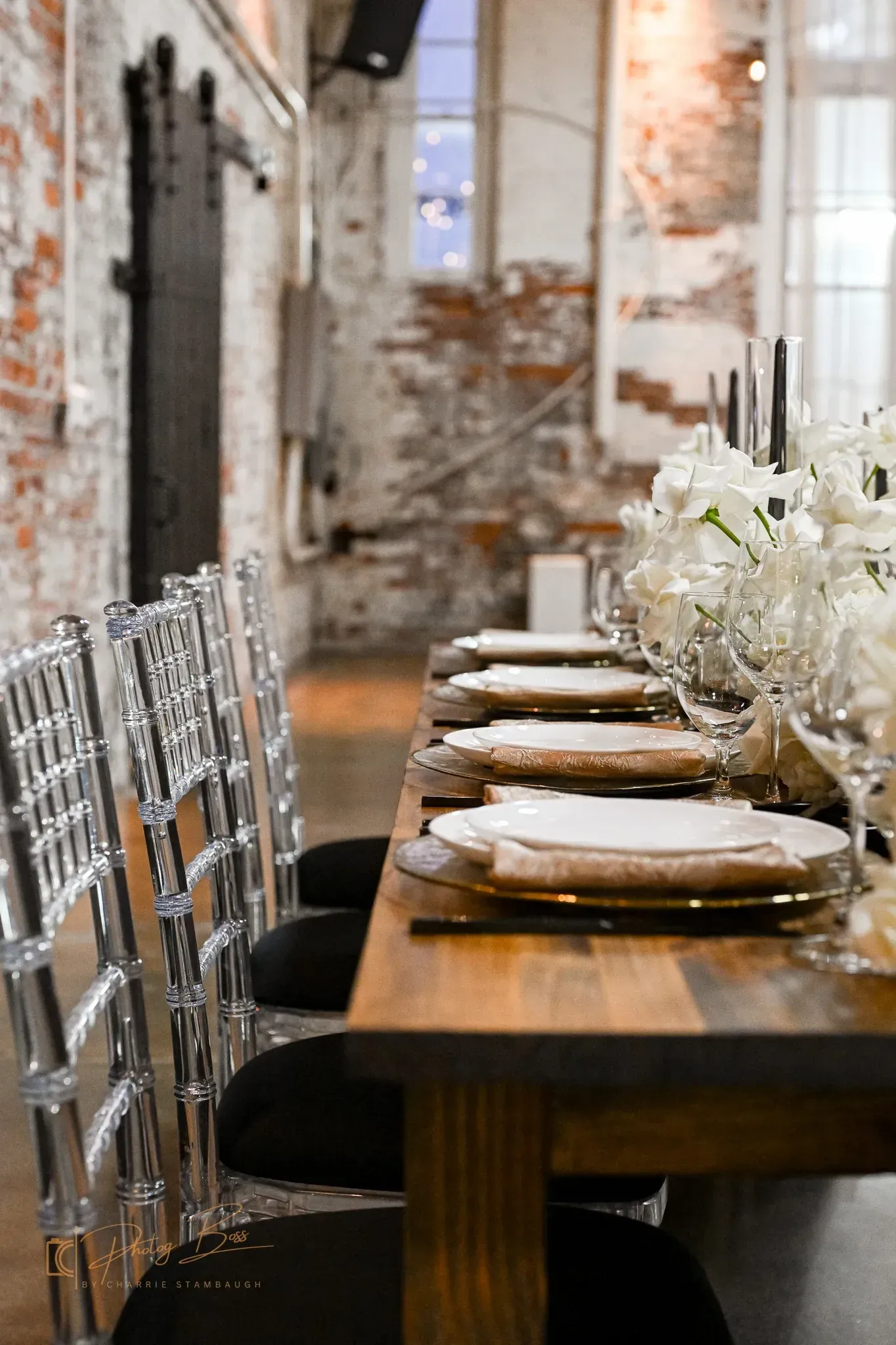 Edison string lights glowing across the brick interior of 24 Shelby, lighting that is built into the venue rather than a hidden wedding venue cost.