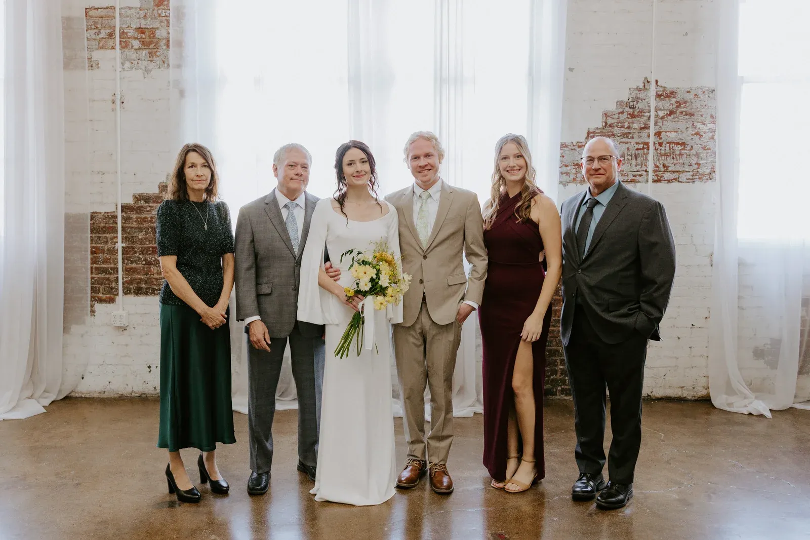 A wedding couple with their parents at 24 Shelby in downtown Indianapolis, a reminder that a trimmed guest list puts an Indiana wedding budget toward the people who matter most.