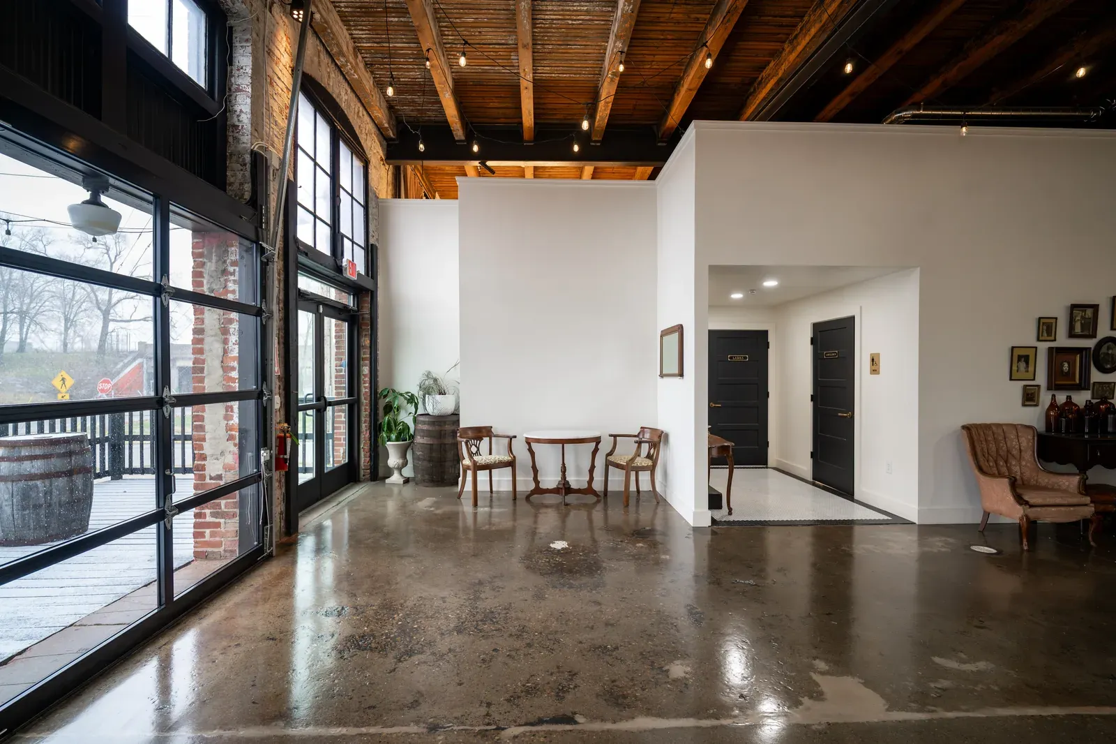 Modern roll-up garage doors at 24 Shelby, the indoor outdoor wedding venue connection that defines the hybrid Indianapolis category, with original brick walls and Edison lights inside.