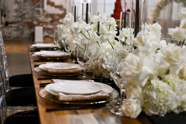 Wedding reception tablescape inside 24 Shelby, a historic downtown Indianapolis wedding venue, with linens, candles, and place settings ready for the caterer to plate dinner.