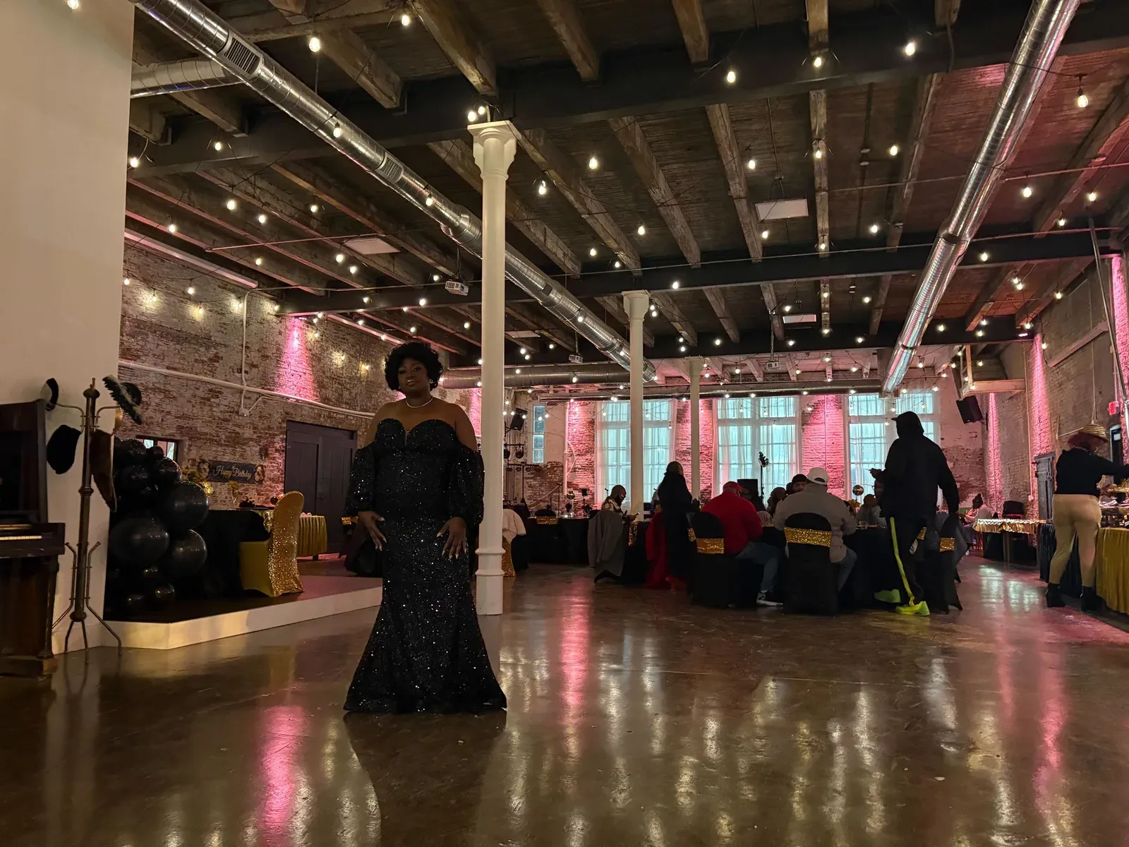The Edison Room at 24 Shelby lit with festive color uplighting for a holiday party in downtown Indianapolis, with Edison string lights and exposed 1898 brick