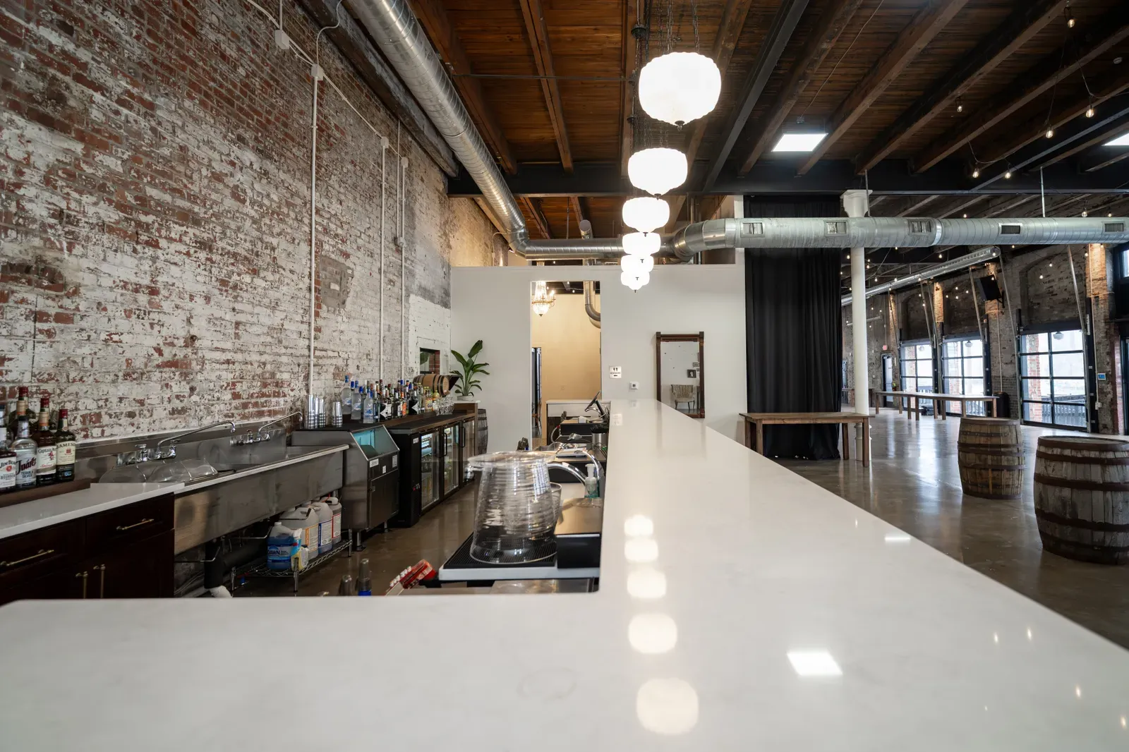 The working bar station at 24 Shelby with sinks, speed rails, and ice wells behind the counter, the in-house bar service required at this Indianapolis wedding venue.