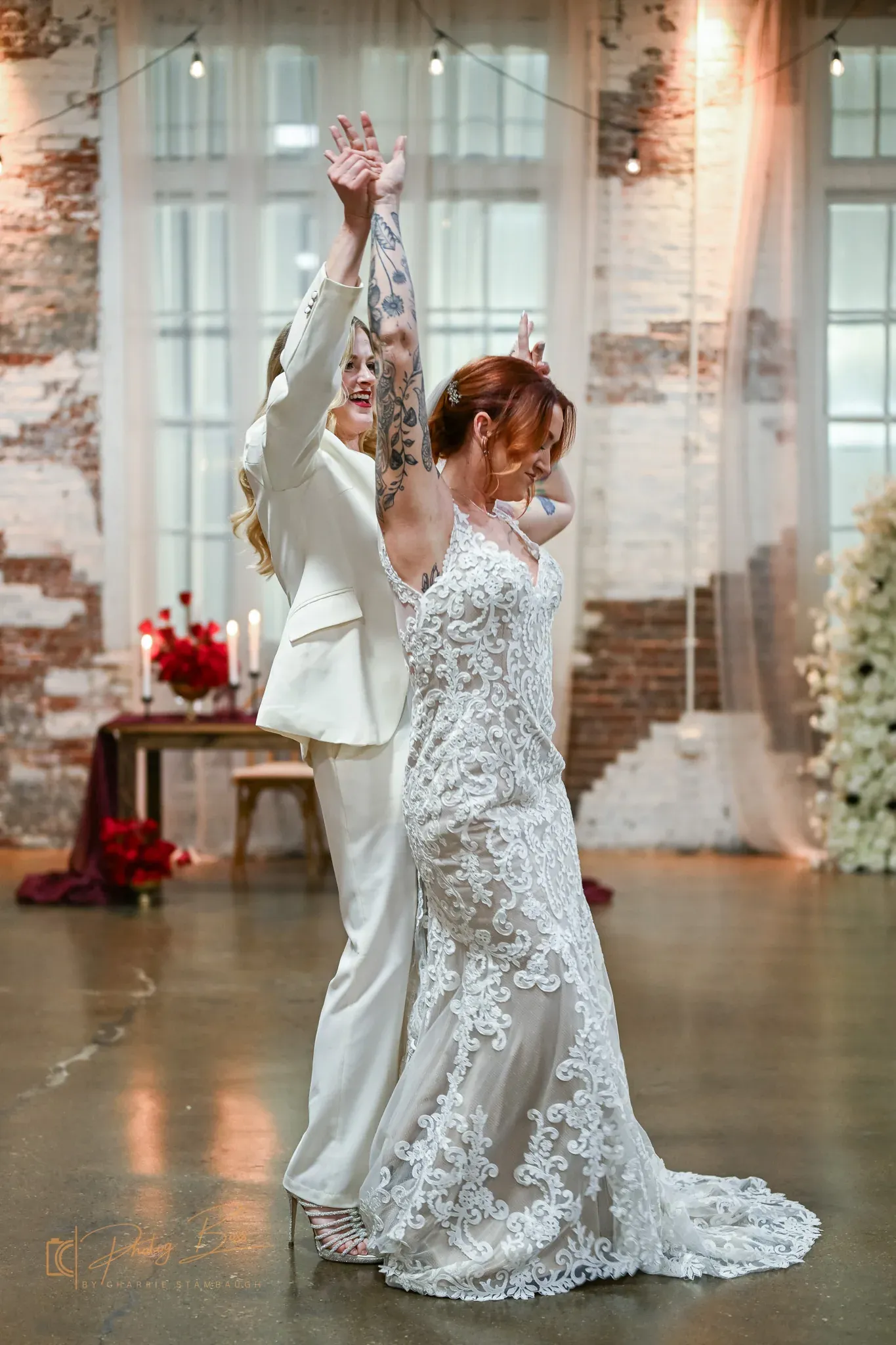 First dance under warm Edison string lights at 24 Shelby with original 1898 exposed brick walls, illustrating the 2026 Neo Deco wedding aesthetic at a Roaring Twenties Indianapolis venue