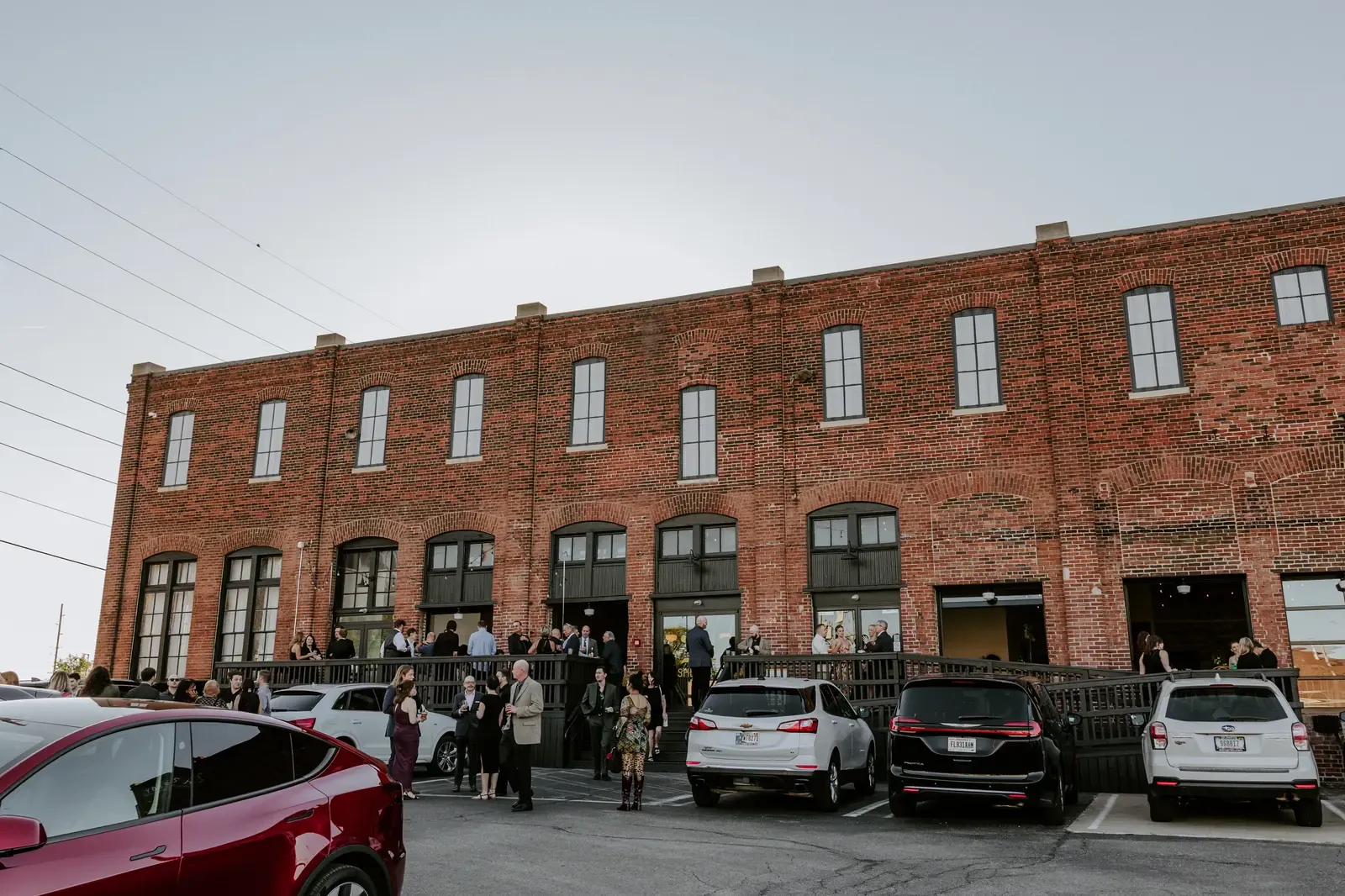 Guests socializing on the outdoor deck of a historic red brick venue in downtown Indianapolis