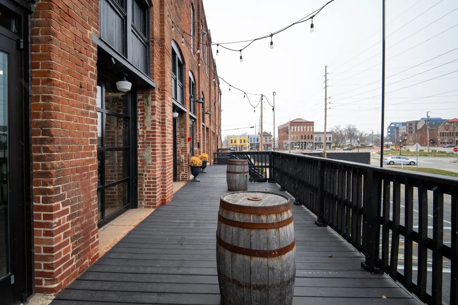 The Prohibition Patio at 24 Shelby, an outdoor deck with whiskey barrel tables and string lights
