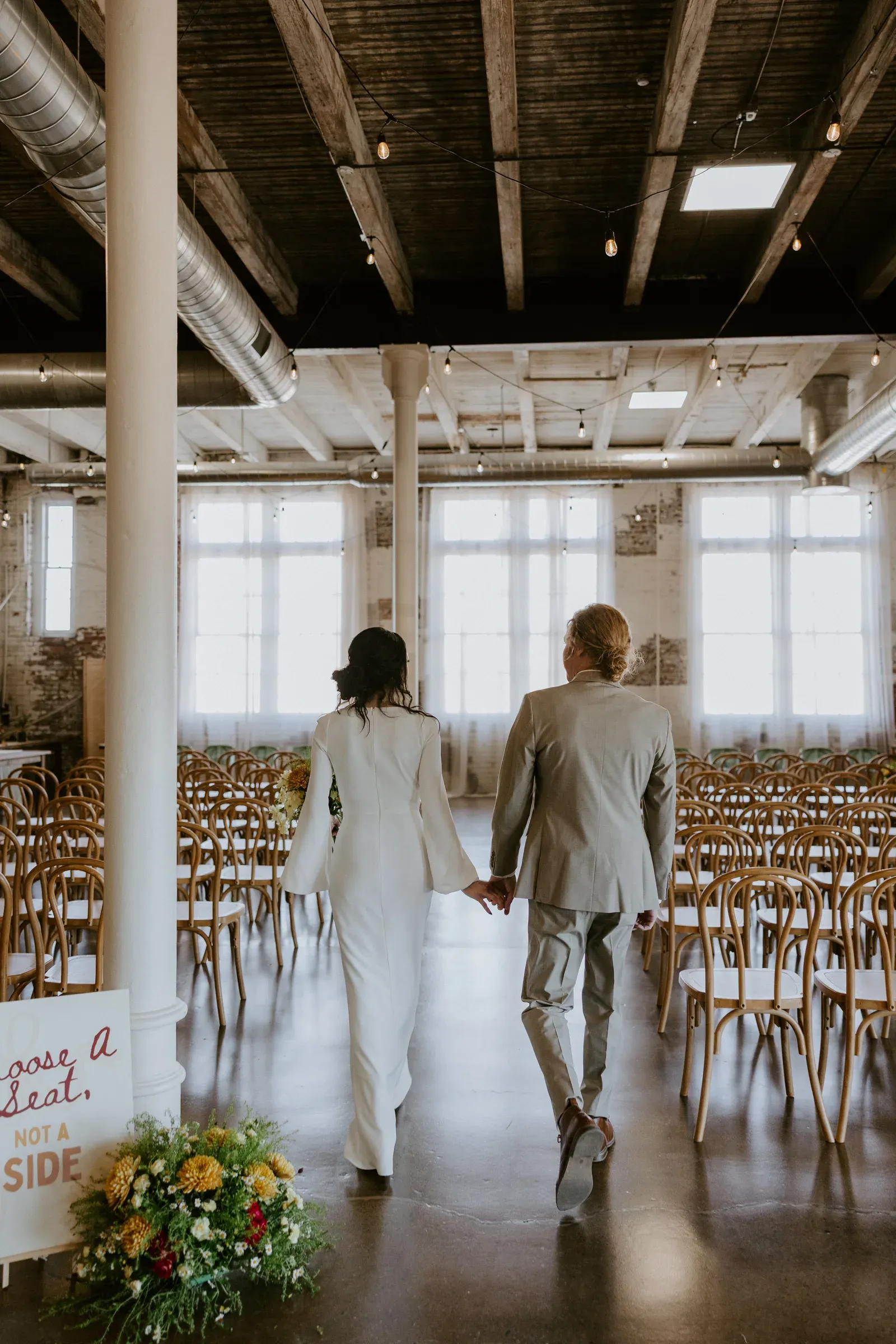 Marin and Chandler's portrait at 24 Shelby on their downtown Indianapolis wedding day, framed by original brick walls and warm natural light